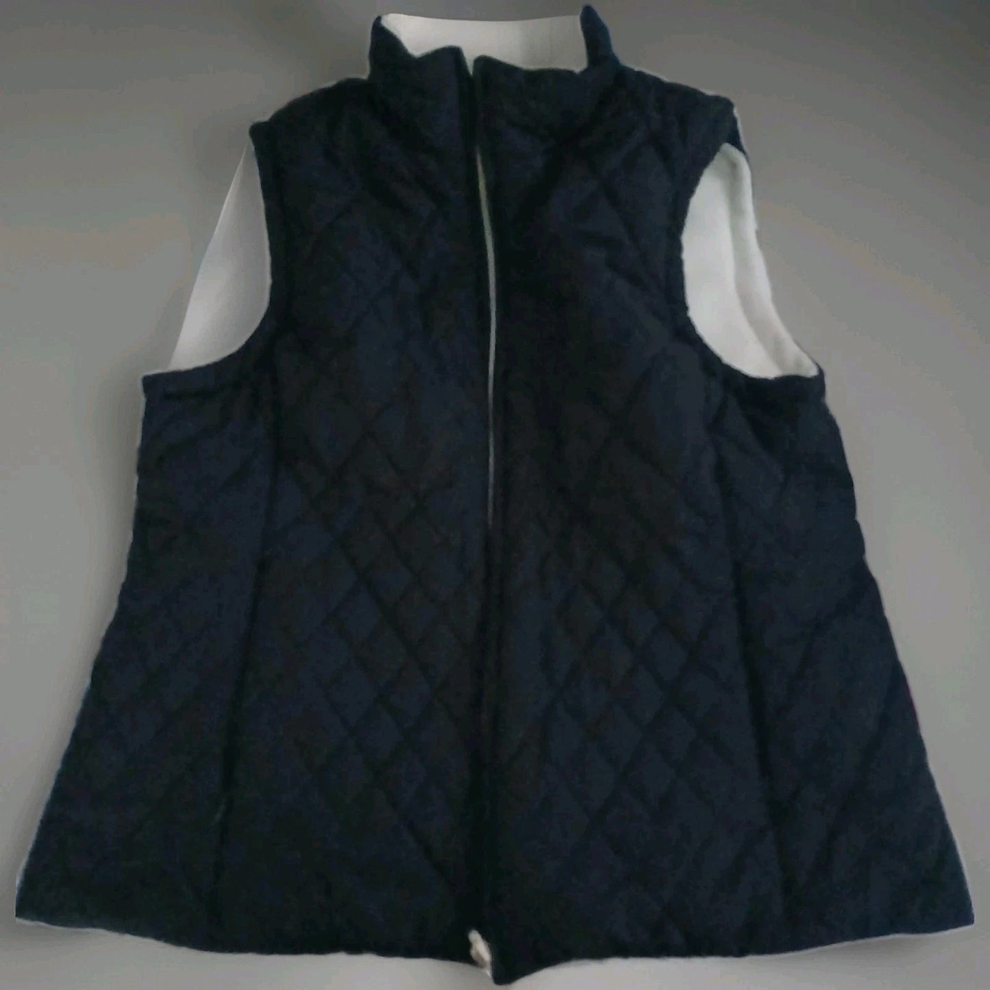 Black Izod puffer vest on gray background