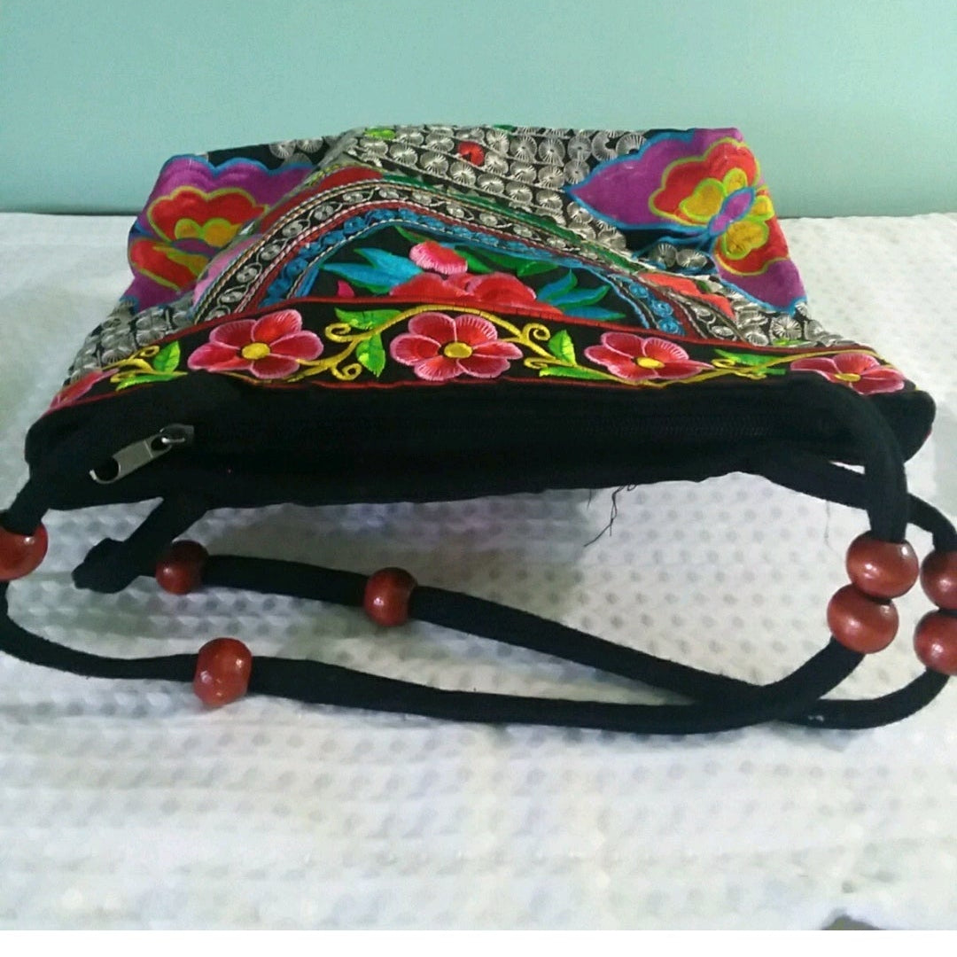 Colorful embroidered bag with floral patterns on a white background