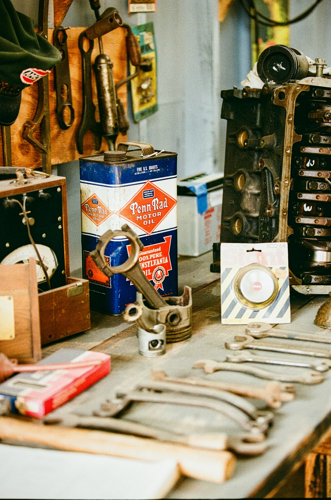 Vintage tools and engine parts on a workbench.