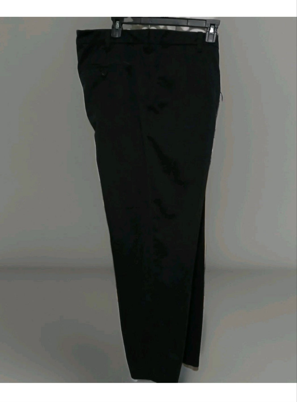 Black pants on a hanger against a plain background