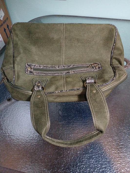 Green leather handbag on a reflective surface