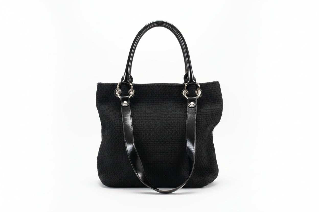 Black textured handbag with silver clasps on a white background