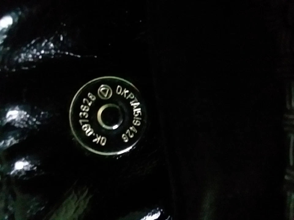 Close-up of a metallic button with text on a dark background