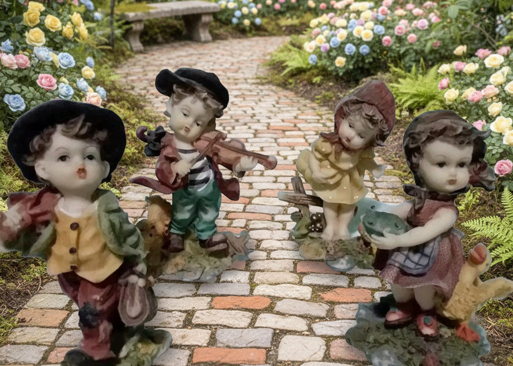 Four figurines of children in a garden setting with green grass and a stone path.