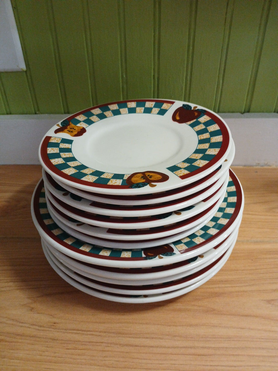 Stack of decorative plates with a checkered pattern on a wooden surface.