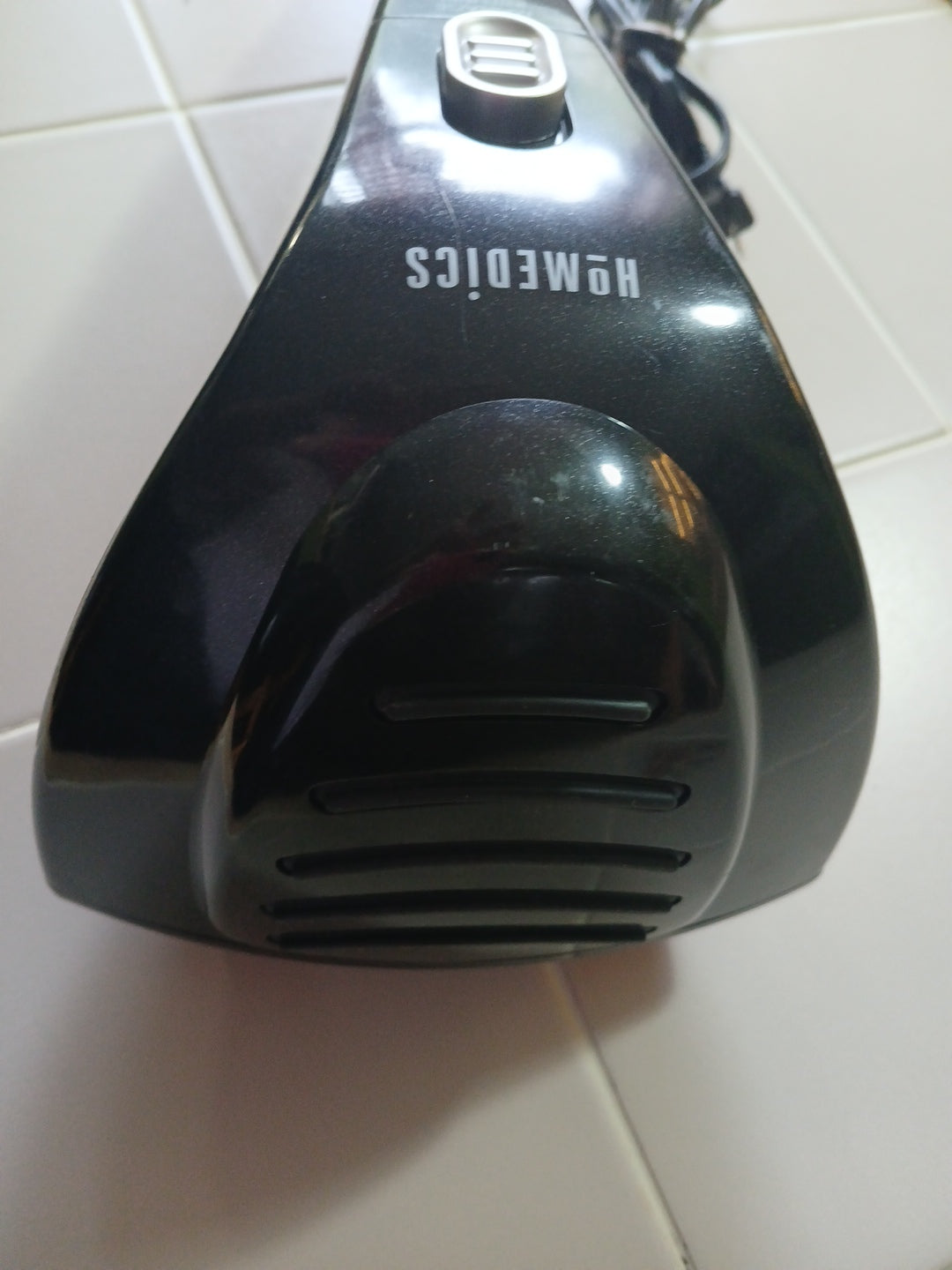 Black appliance with 'HoMedics' branding on a tiled floor