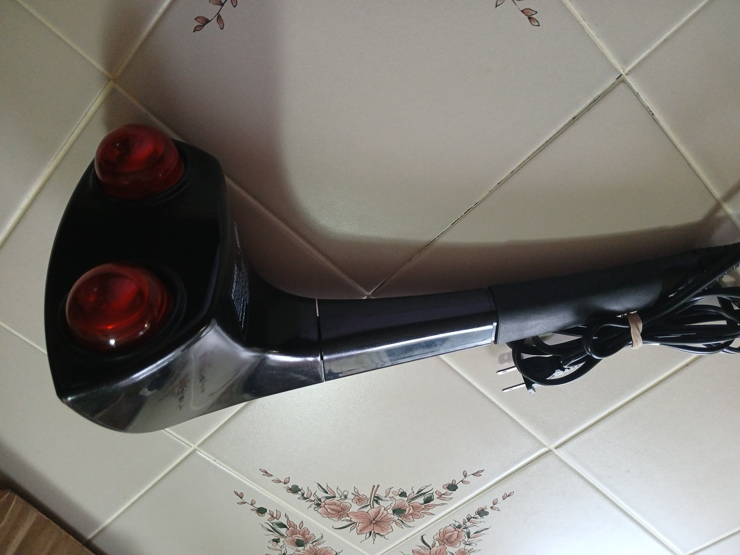 Black and red  massager on a tiled floor
