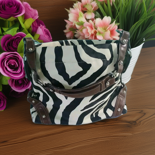 zebra purse on table with flowers around it 