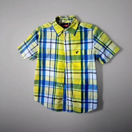 Plaid shirt with yellow, blue, and green pattern on a plain background